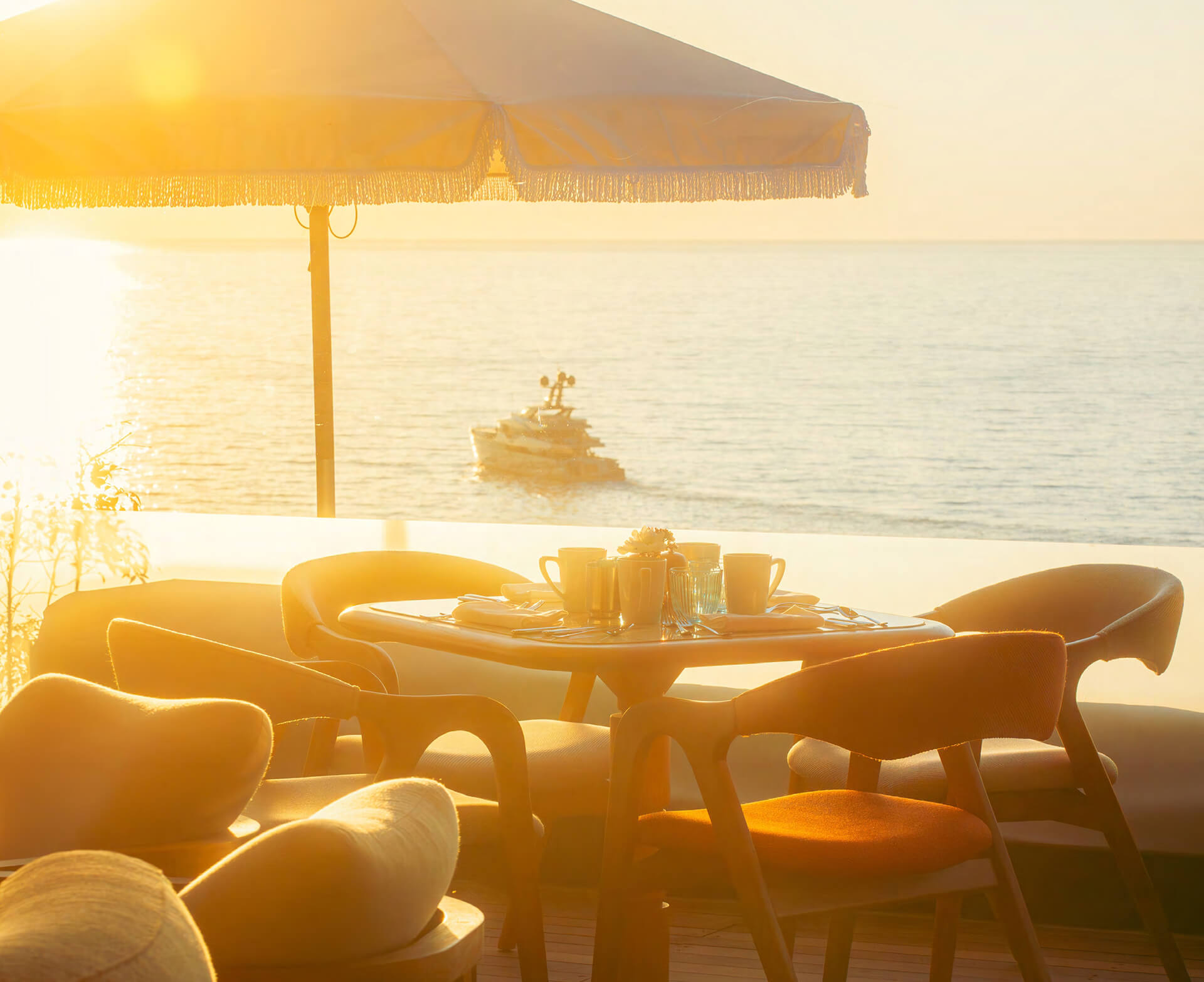 Private terrace dining overlooking the Arabian Gulf at sunset